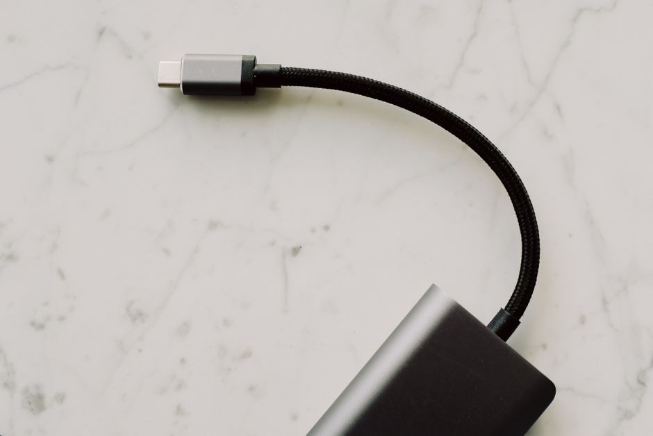 책상 위 깔끔하게 정리된 USB-C 독과 연결된 노트북, 모니터